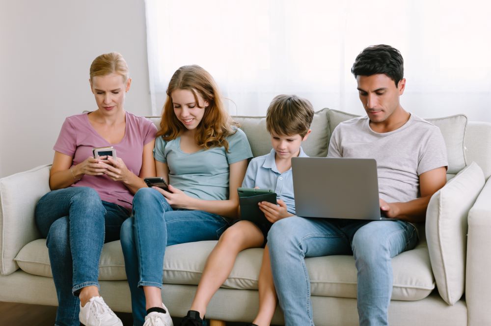 family looking at electronic devices