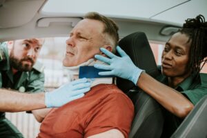 man in car with neck injury