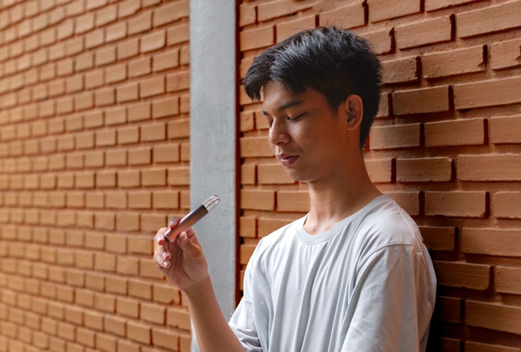 boy looking at vape pen
